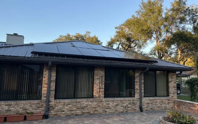 Black solar panels on a brick home