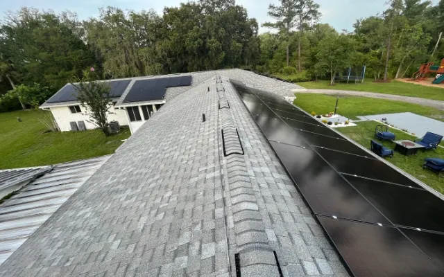 Solar panels along a shingle roof ridge