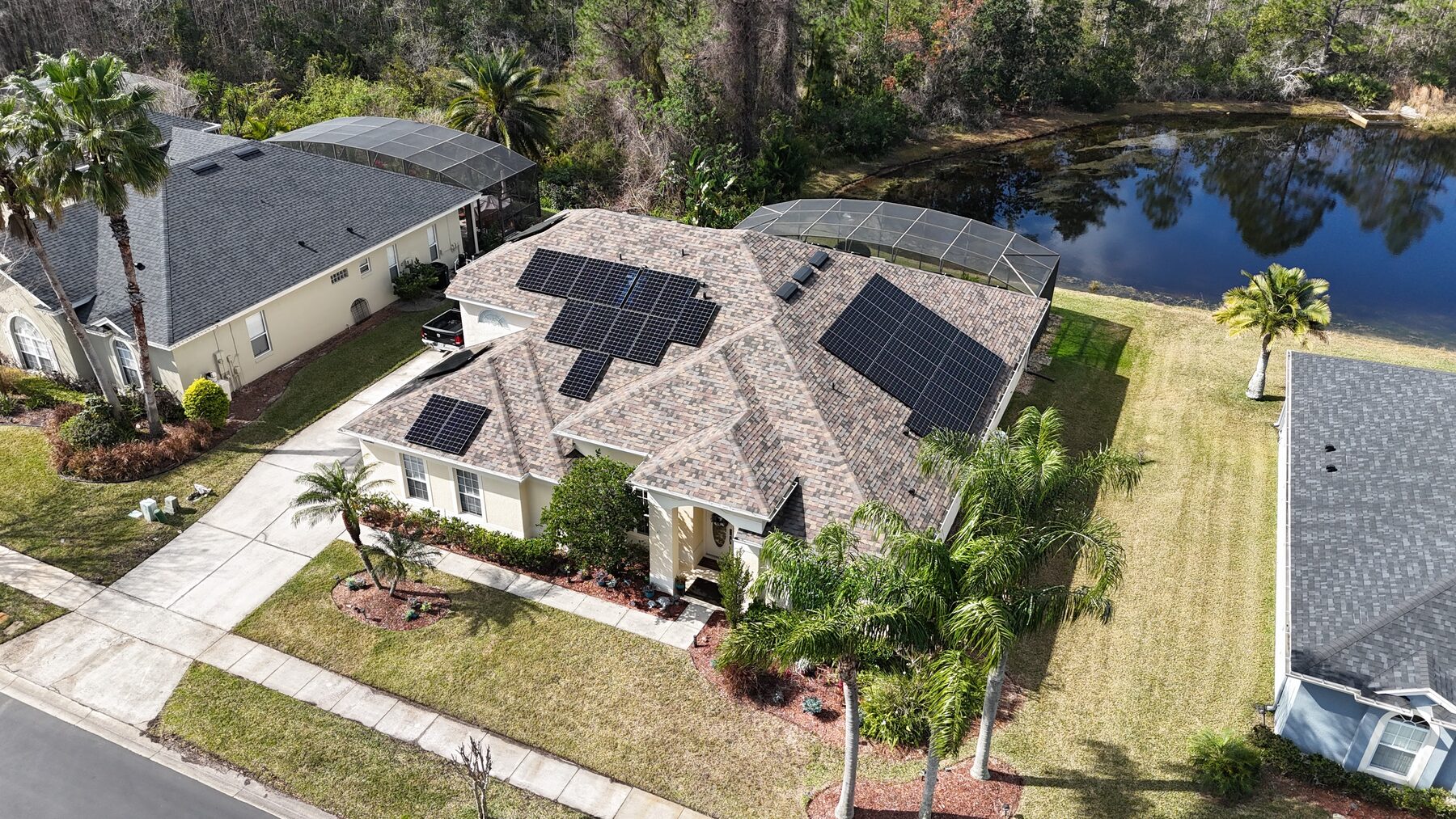 Solar panels on a lakeside Florida home surrounded by palms