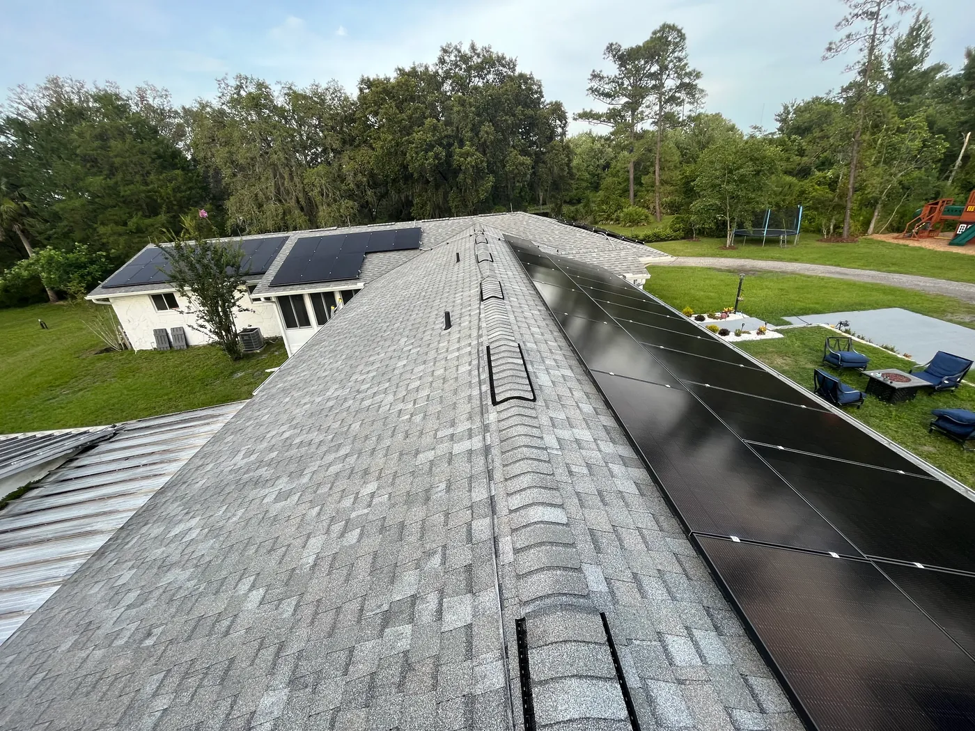 Roof-level view of black solar panels installed across multiple roof sections